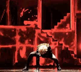 a man is doing a handstand on a stage in front of stairs