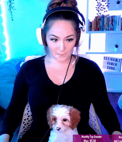 a woman sitting in front of a sign that says desirable gamer gang on it