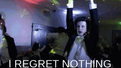 a man in a tuxedo is dancing with his arms in the air and the words i regret nothing below him