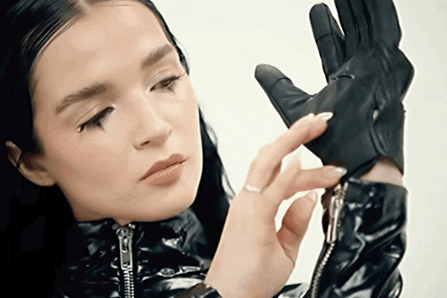 a woman wearing a leather jacket and gloves