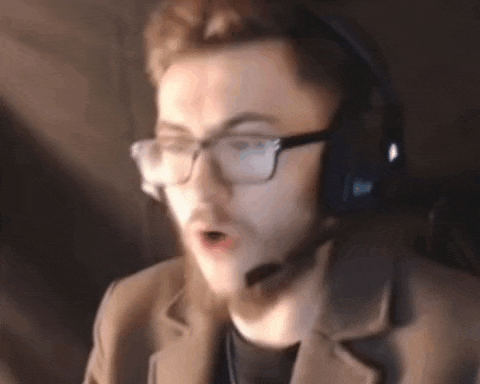a man wearing glasses and headphones is sitting in front of a computer screen .