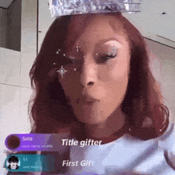 a woman with a crown on her head is blowing bubbles .