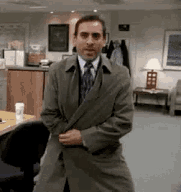 a man in a suit and tie is standing in a room in an office .