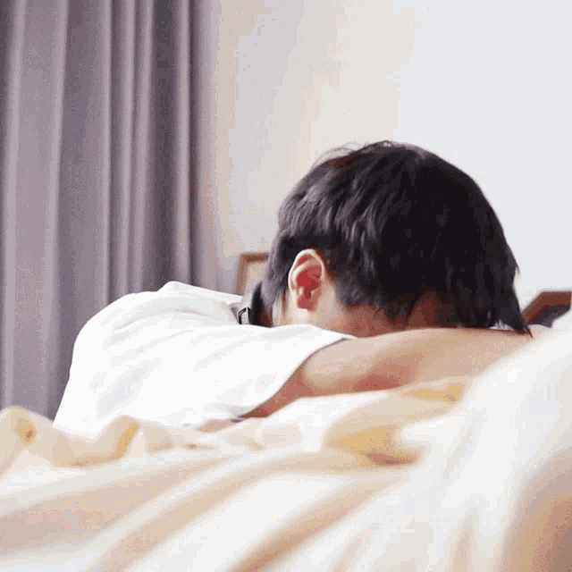 a person laying on a bed with their head down