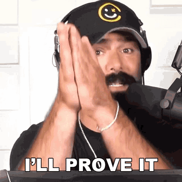a man wearing headphones and a hat says " i 'll prove it " in front of a microphone
