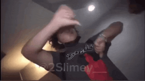 a man is dancing in a room with his hands in the air .