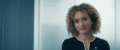 a woman with curly hair wearing a headset with the letter d on the front