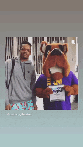 a man is standing next to a mascot wearing a purple shirt that says ualbany theatre