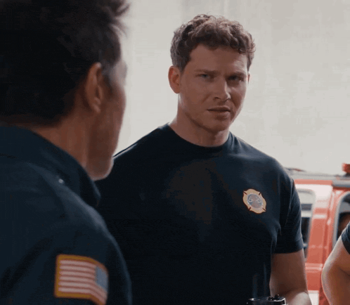 a man wearing a black shirt with a fire department badge on it