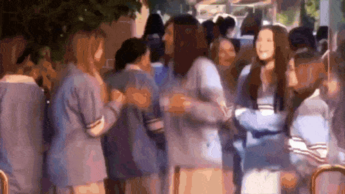 a group of women are standing next to each other in a crowd .
