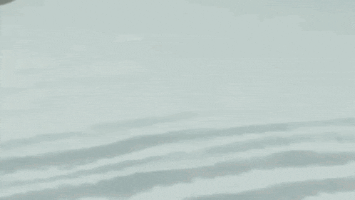 a cartoon character with a skull on his head is standing on a snowy surface .