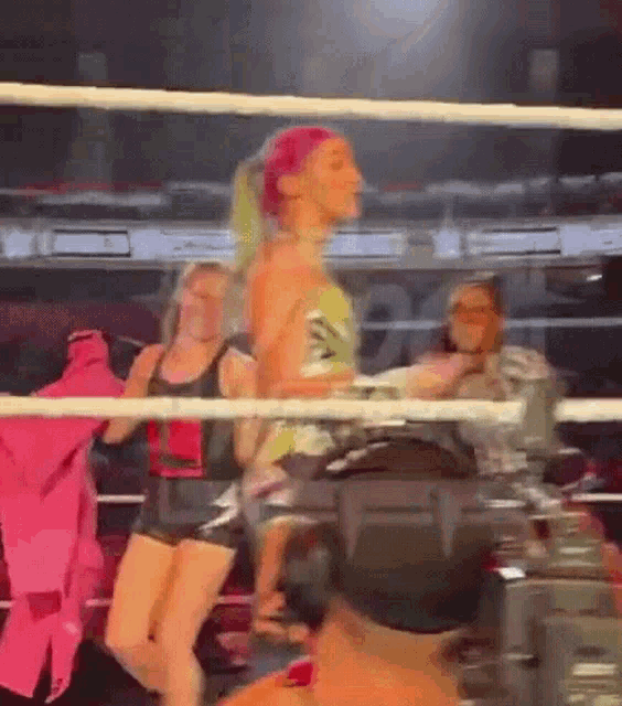a woman is standing in a boxing ring with a camera .