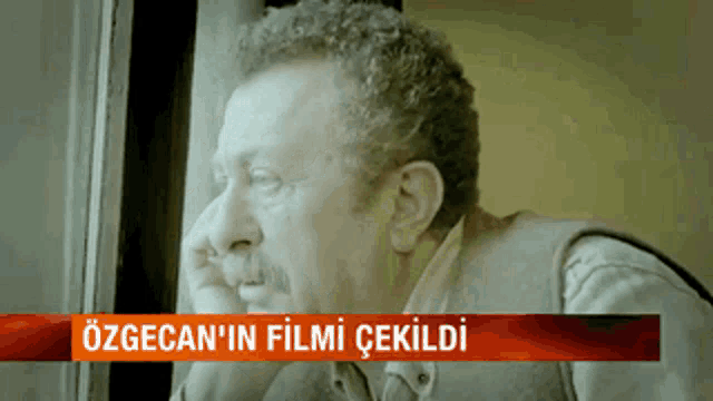 a man is looking out of a window with the caption özgecan 'in film cekildi