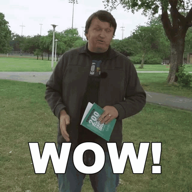 a man is holding a book that says wow on it