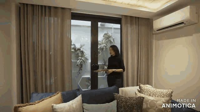 a woman is standing in a living room with the words made in animotica on the bottom right