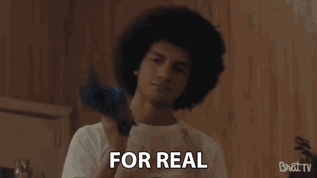a man with an afro says " for real " in a video