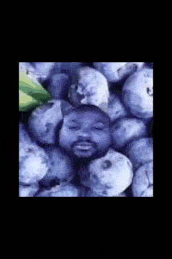 a man with a beard is surrounded by a bunch of grapes