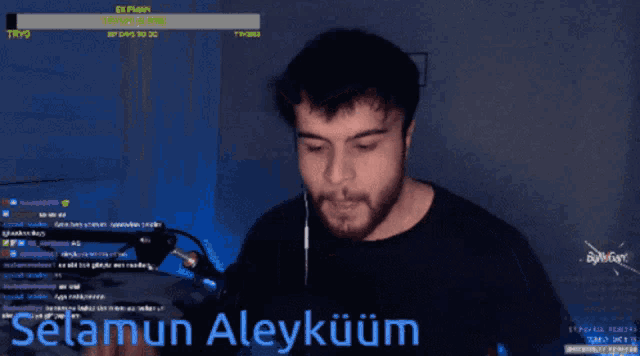 a man with a beard is talking into a microphone and the words selamun aleykuum are on the screen