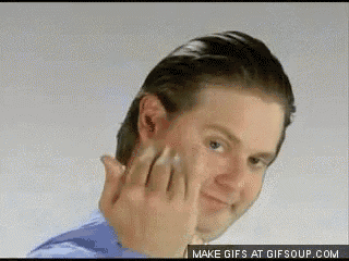 a man in a blue shirt is making a funny face with his fingers .