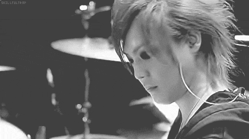 a black and white photo of a person playing a drum set with the words skillfultrap below them