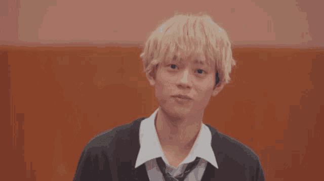 a young man giving a peace sign with both hands