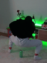 a woman in a black sweater and white pants is squatting in a living room