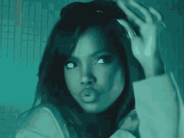 a woman is wearing sunglasses and making a funny face in a dark room