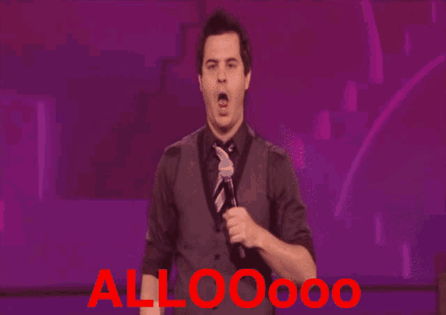 a man in a suit and tie holds a microphone in front of the word alloooo