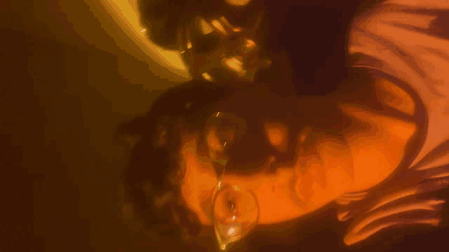a close up of a person wearing glasses with a yellow background