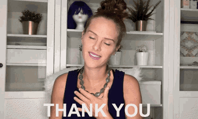 a woman says thank you in front of a shelf