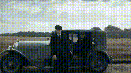a man in a suit and tie is getting out of a car .