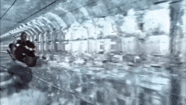 a person riding a motorcycle in a tunnel with a lot of windows