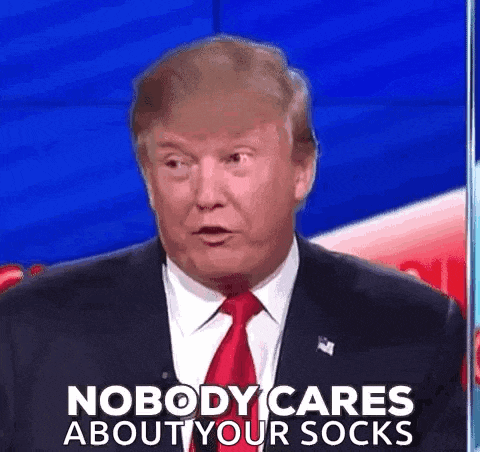 donald trump is wearing a suit and tie while talking on a television show and says nobody cares about your socks .
