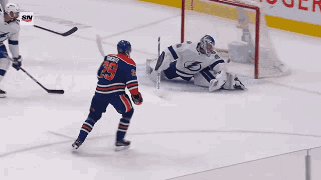 a hockey player wearing a number 29 jersey stands on the ice