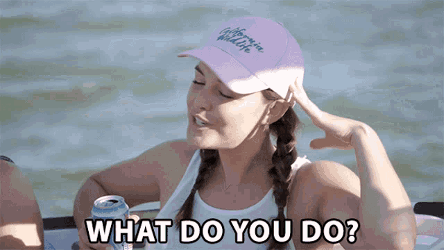 a woman wearing a pink california wildlife hat is holding a can of beer