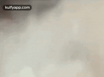 a close up of a man 's face in a room with smoke coming out of his mouth .