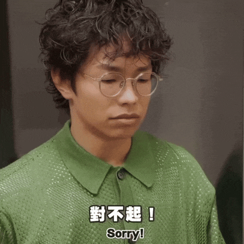 a man wearing glasses and a green shirt says " sorry "