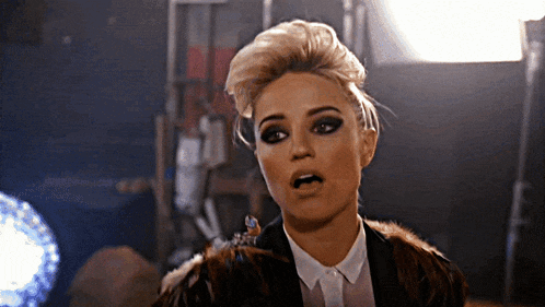 a woman wearing a fur coat is making a funny face with her mouth open