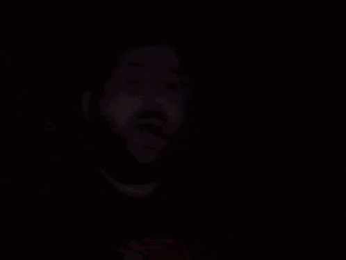 a blurry picture of a man with a beard wearing glasses