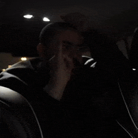 a man is sitting in a dark room giving the middle finger