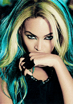 a woman with blue and yellow hair is wearing a black top