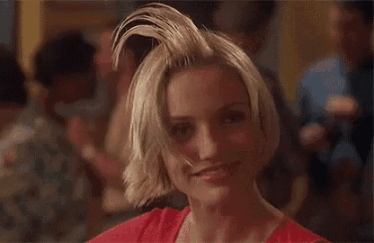 a woman with short blonde hair is making a funny face .