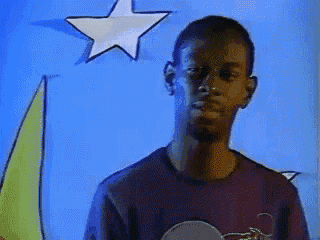 a man in a purple shirt is standing in front of a star