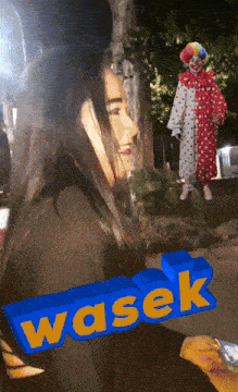 a clown in a red and white polka dot outfit is standing in front of a woman with the word wasek on the bottom