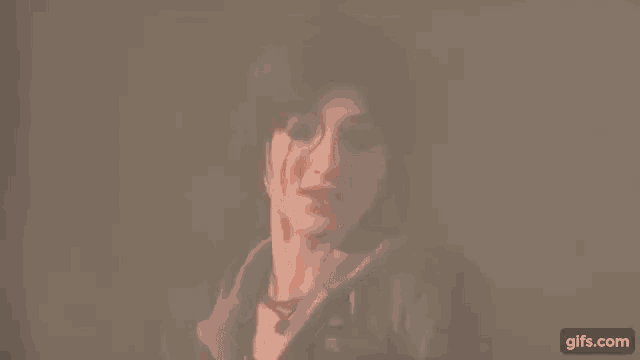 a close up of a woman 's face in a dark room with a blurred background .