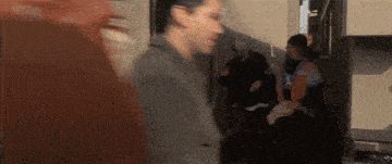 a blurry picture of a group of people walking down a hallway .