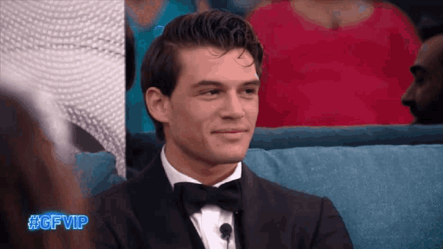 a man in a tuxedo is sitting on a couch with the hashtag #gfvip on the bottom right