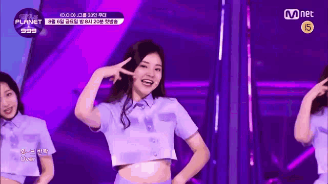 a girl in a purple crop top is dancing on a stage