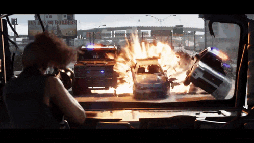 a billboard that says fun is no borders is behind a car on fire
