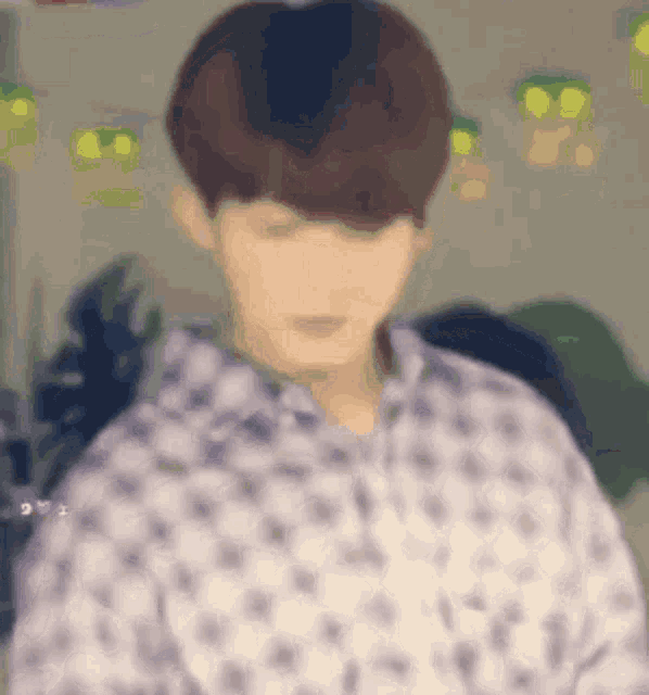 a blurry picture of a man wearing a white shirt with a pattern .